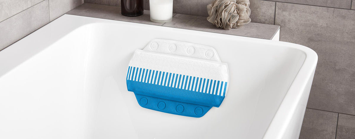 Blau-weißes Nackenkissen liegt in einer weißen Badewanne.