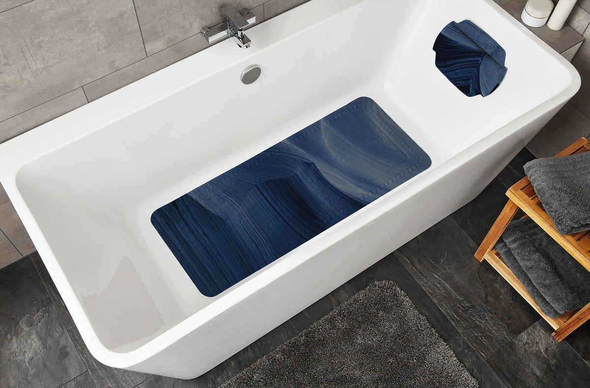 Weiße Badewanne mit blauer Anti-Rutsch-Matte und blauem Kopfkissen
