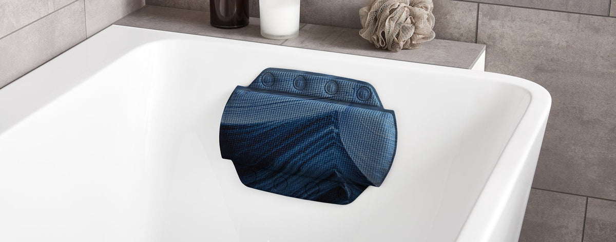 Blaues Nackenkissen in weißer Badewanne im hellen modernen Badezimmer
