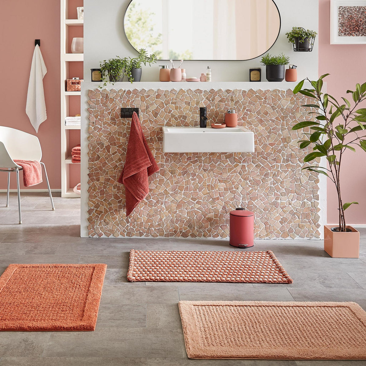 Modernes Bad mit Waschbecken, rosafarbenen Matten und Accessoires