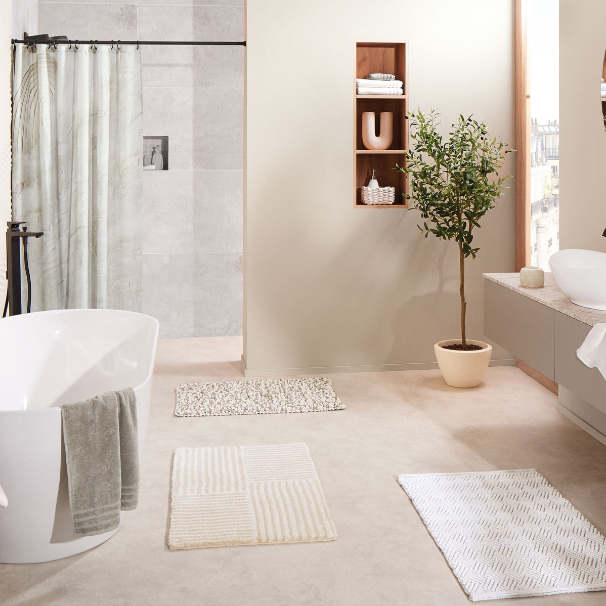Modernes Bad mit freistehender Wanne, Duschbereich, Teppichen und Pflanze
