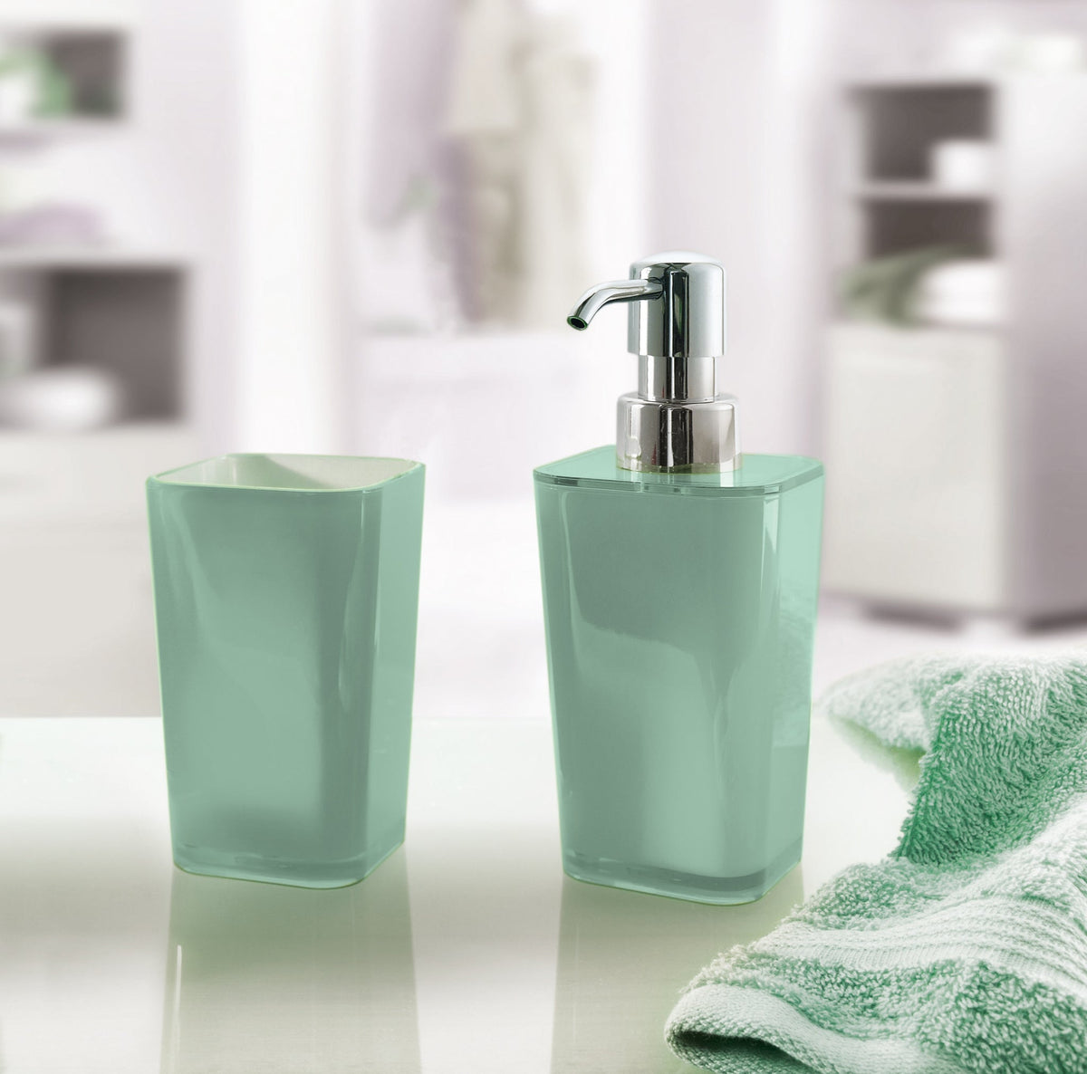 Mintgrünes Seifenspender-Set mit Becher neben gestreiftem Handtuch