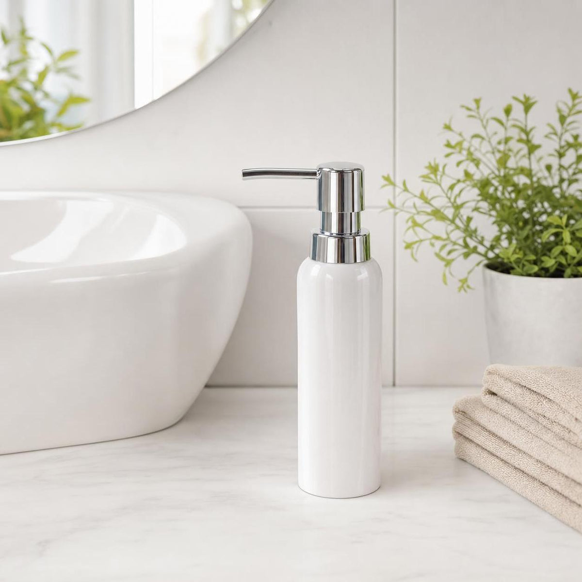 Weißer Seifenspender steht neben Waschbecken, Pflanze und Handtüchern.