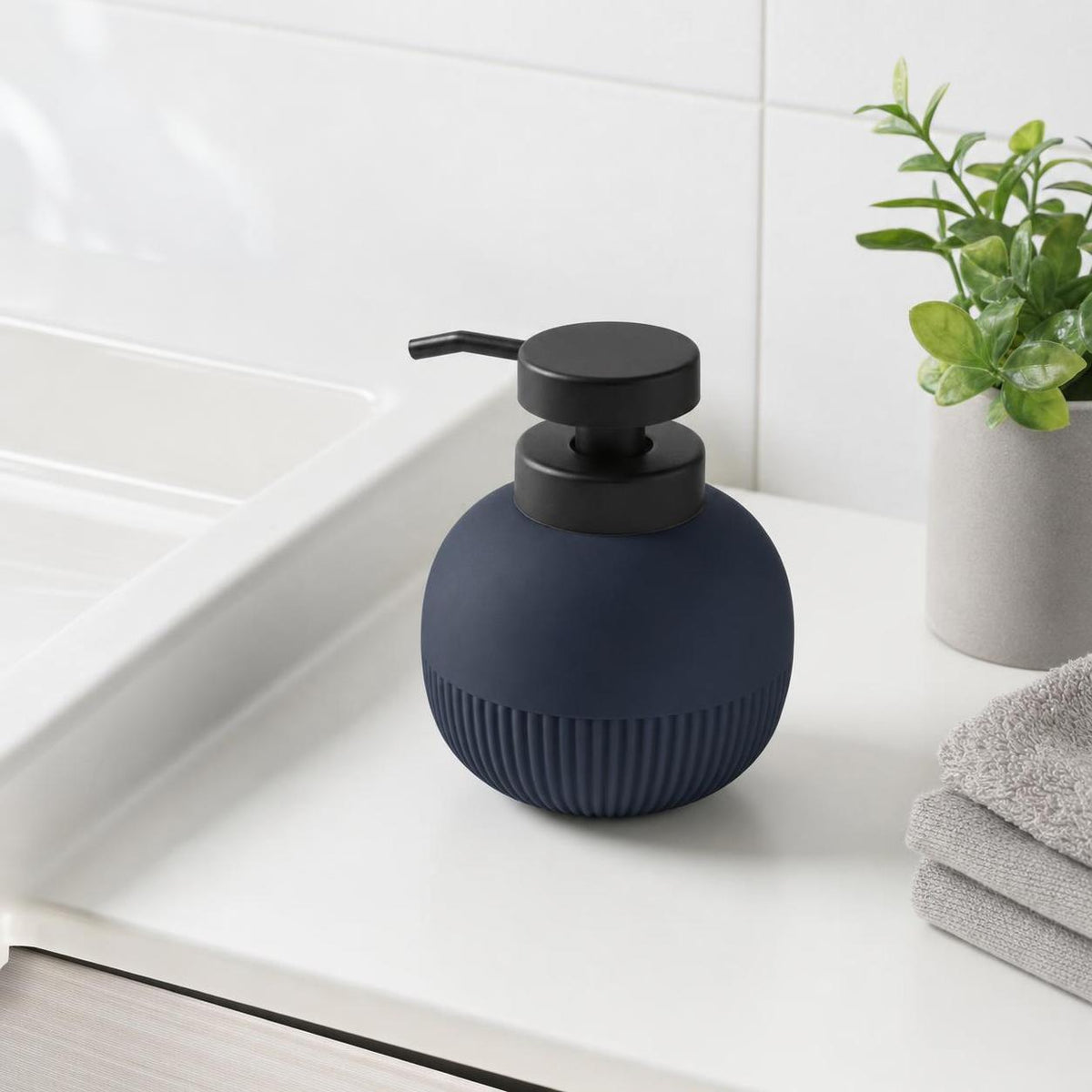 Blauer Seifenspender mit schwarzer Pumpe steht am Waschbecken.
