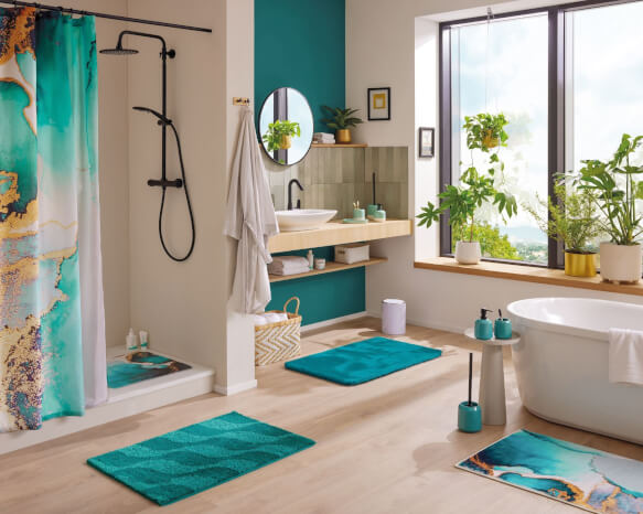 Modernes Bad mit türkisfarbenen Teppichen, Dusche, Wanne und Pflanzen.