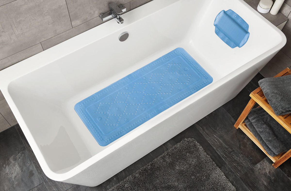 Weiße Badewanne mit hellblauer rutschfester Badematte und Kissen
