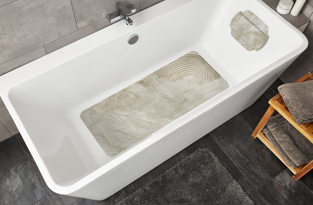Weiße Badewanne mit beiger Antirutschmatte und grauem Badteppich