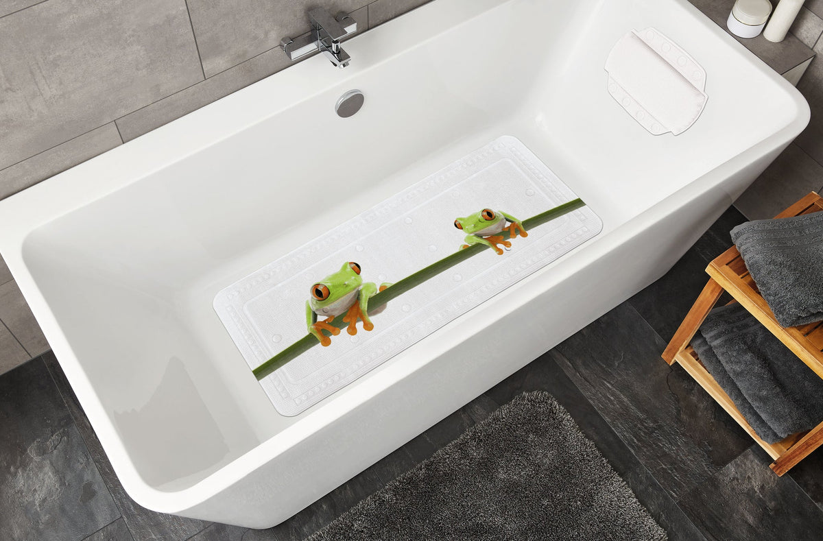 Weiße Badewanne mit rutschfester Badematte und zwei Froschmotiven