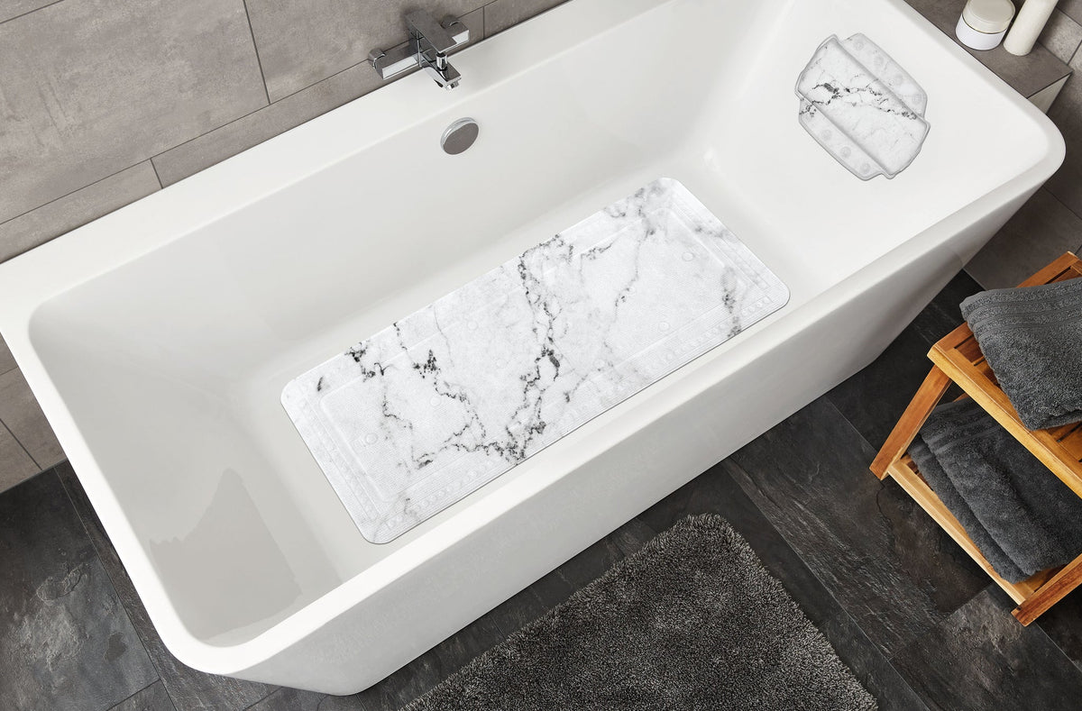 Weiße Badewanne mit grauer Marmor-Antirutschmatte und grauem Badteppich