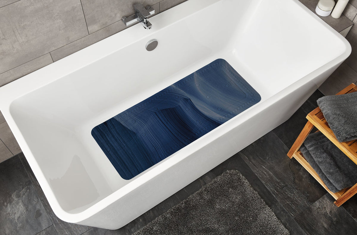 Weiße Badewanne mit dunkelblauer rutschfester Badematte im Inneren unten