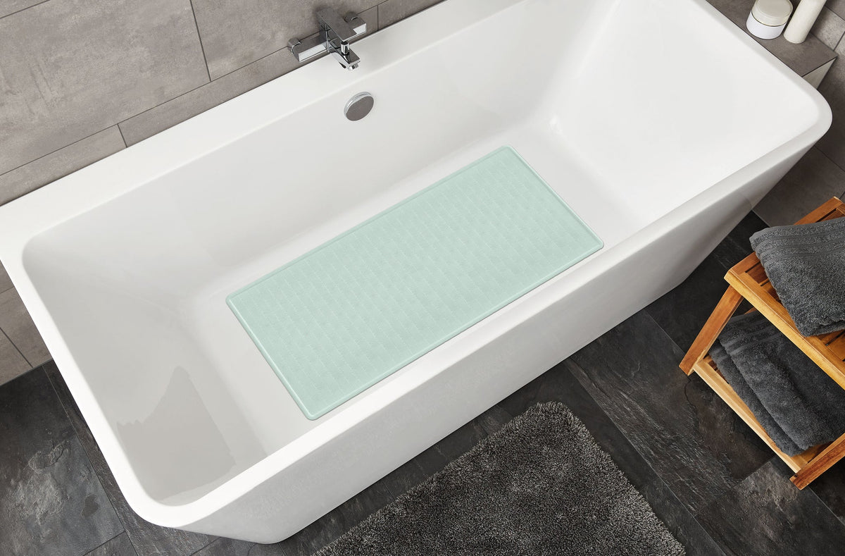 Weiße Badewanne mit mintgrüner rutschfester Badematte im Innenraum