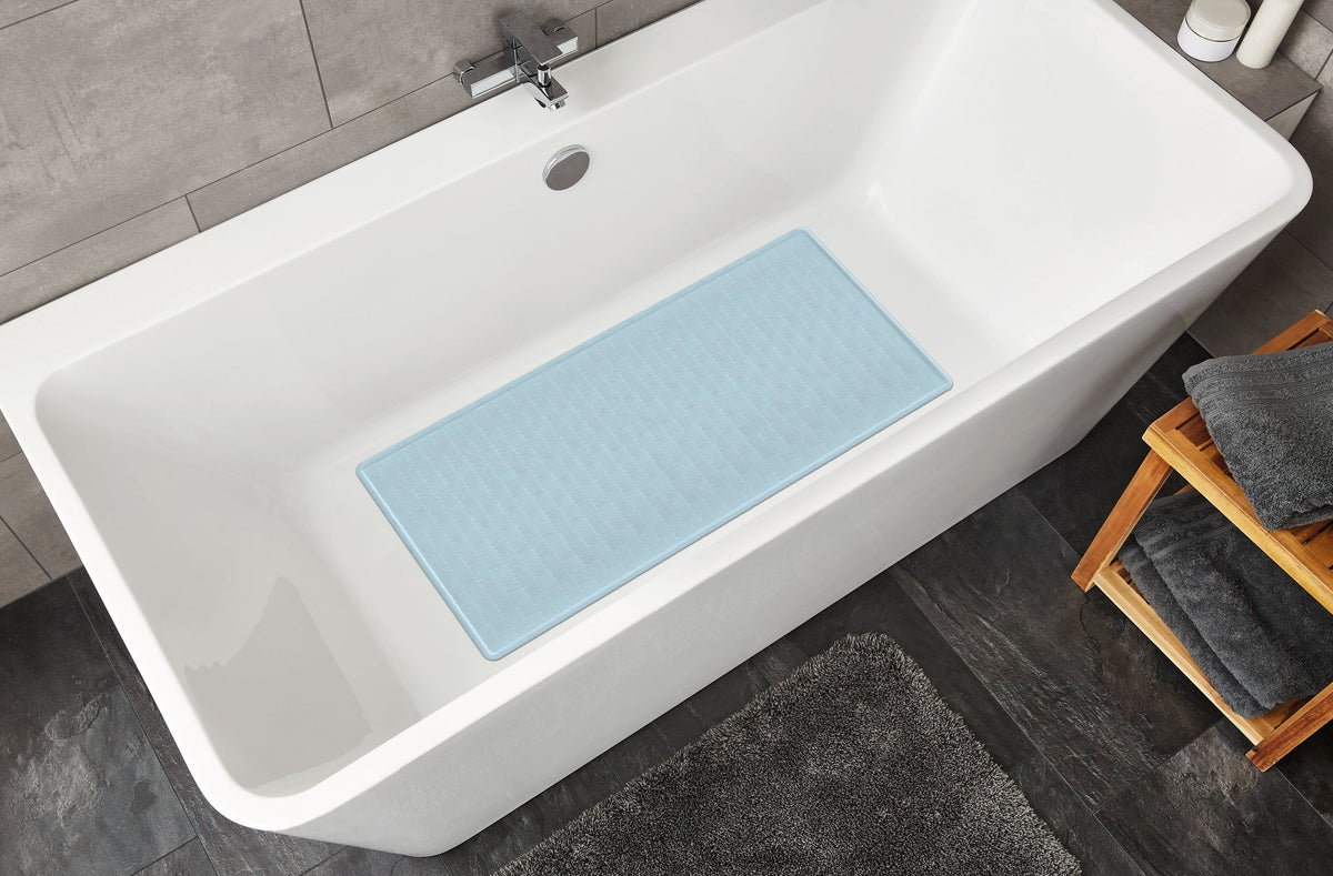 Weiße Badewanne mit hellblauer Antirutschmatte und grauer Badematte