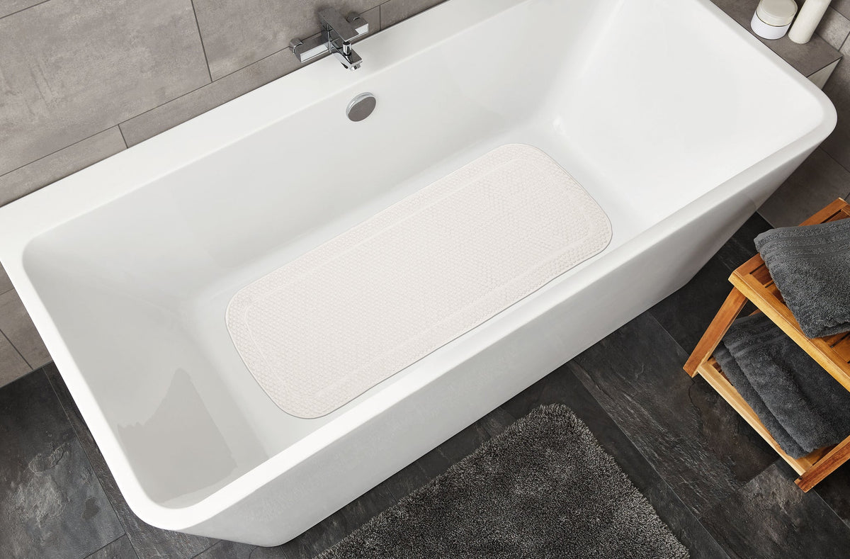 Weiße Badewanne mit rutschfester Badematte, Holzschemel und Handtüchern