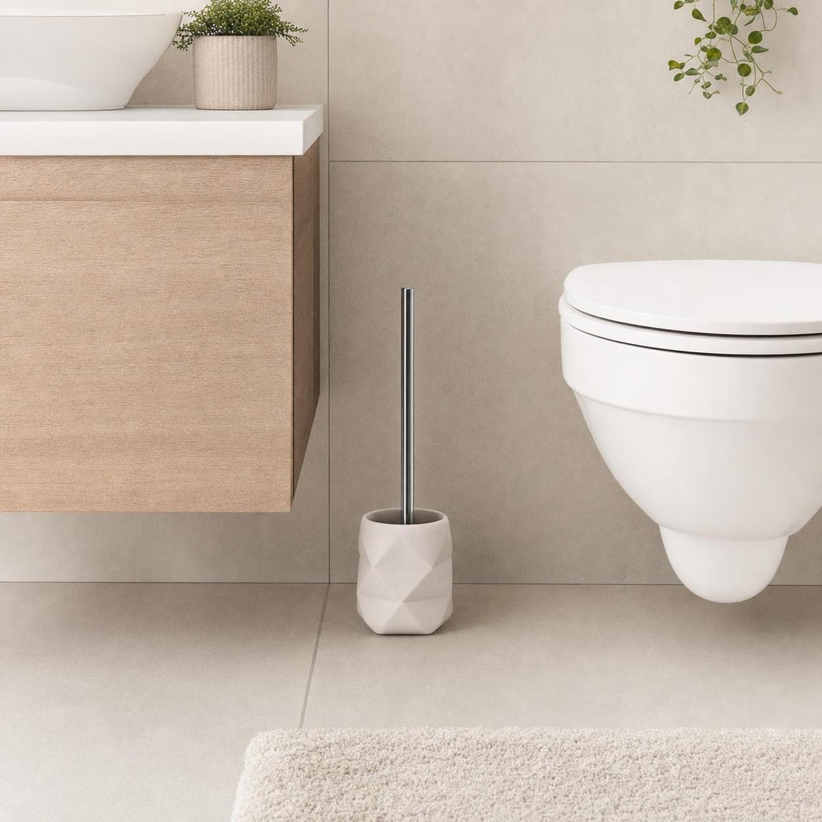 Weiße WC-Bürste im facettierten Halter neben der Toilette.