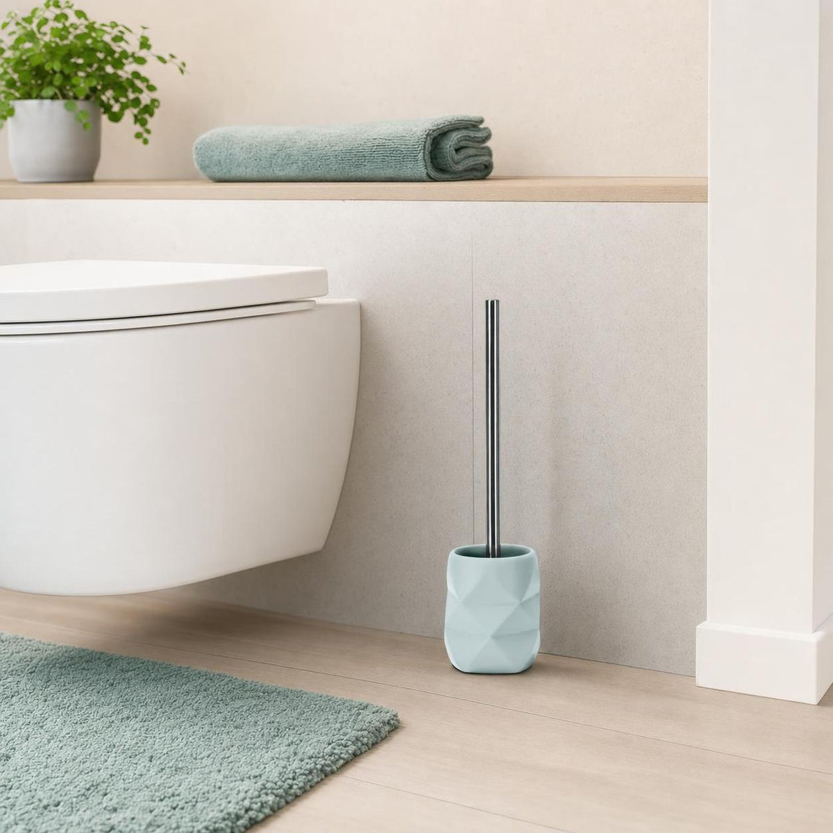 Hellblaue WC-Bürste mit Halter steht neben der Toilette im Bad.