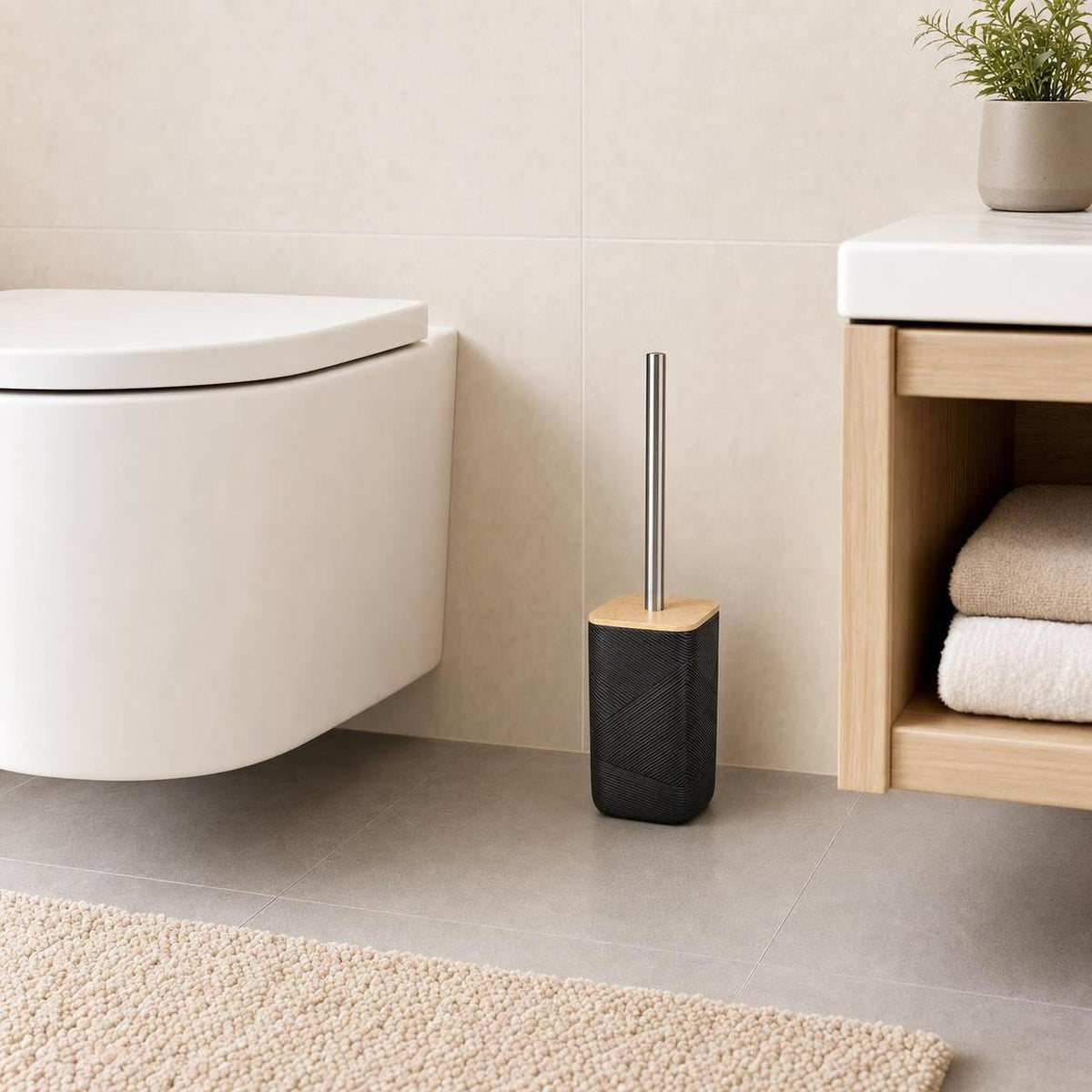Eine schwarze WC-Bürste mit Holzdeckel steht neben der Toilette.