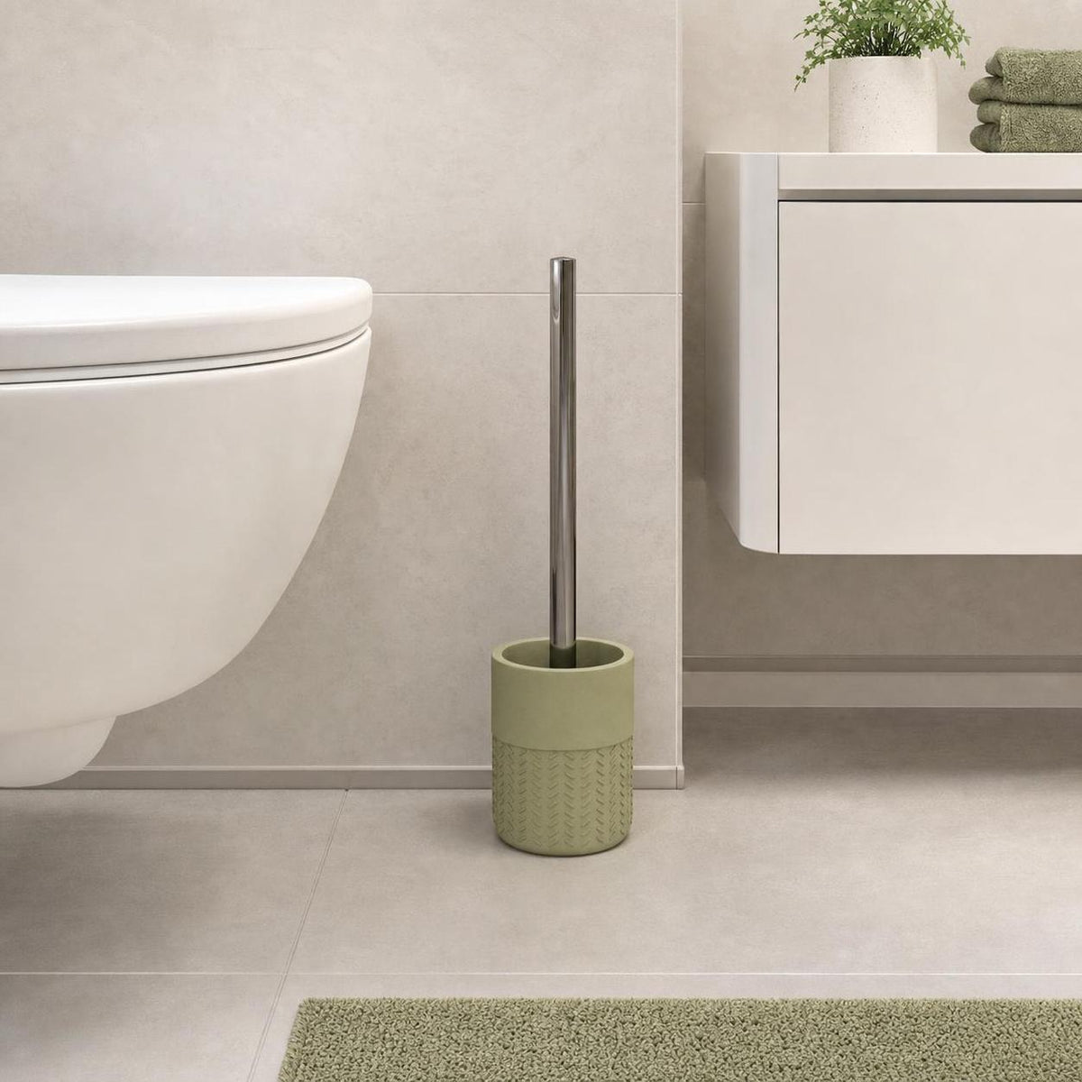 Eine grüne WC-Bürstengarnitur steht neben der Toilette im Bad.