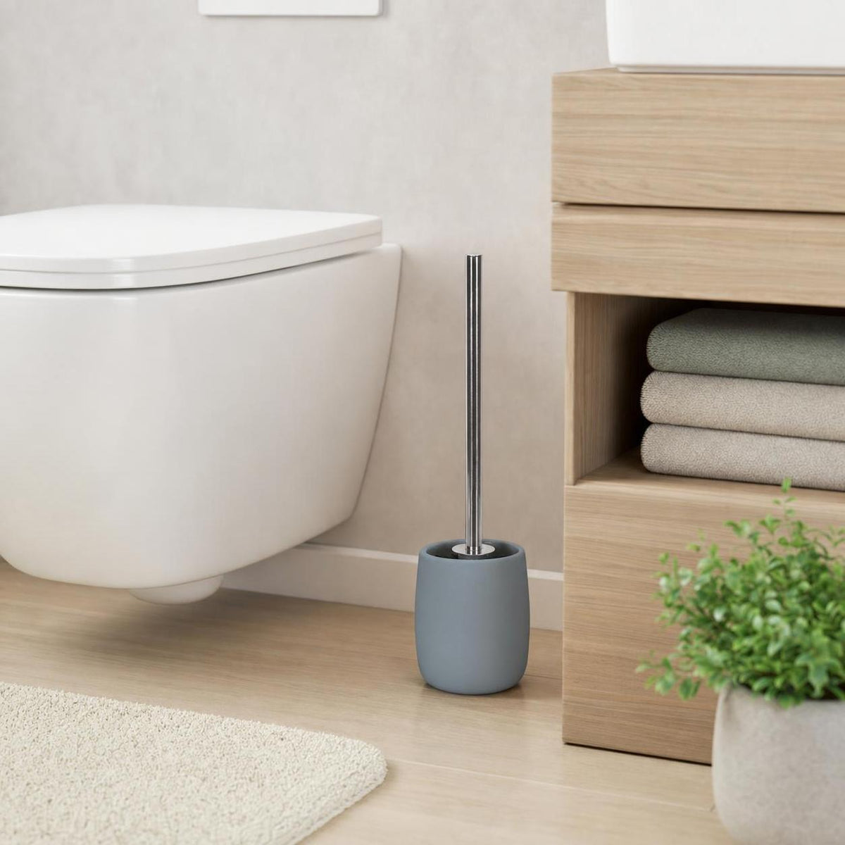 Graue WC-Bürste mit Halter steht neben der Toilette im modernen Bad.