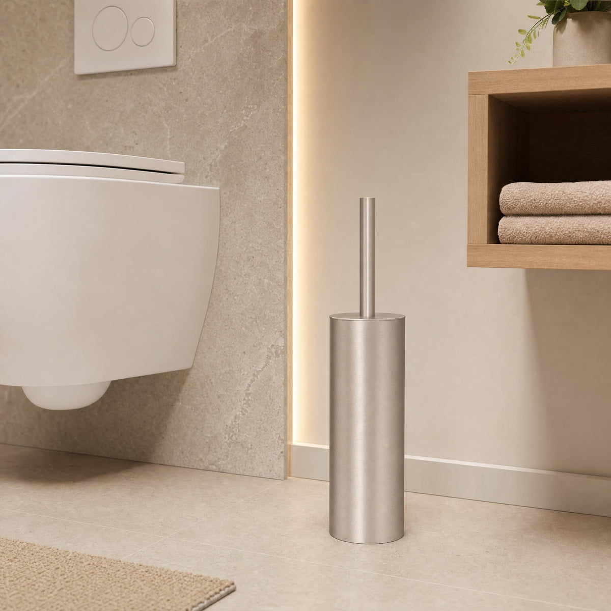 Silberfarbene WC-Bürste vor modernem Hänge-WC im warmen Badezimmer.