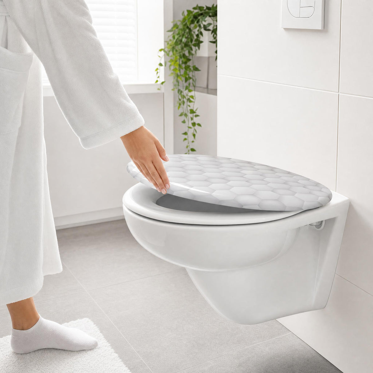 Person im Bademantel schließt WC-Sitz mit grauem Wabenmuster im Bad.