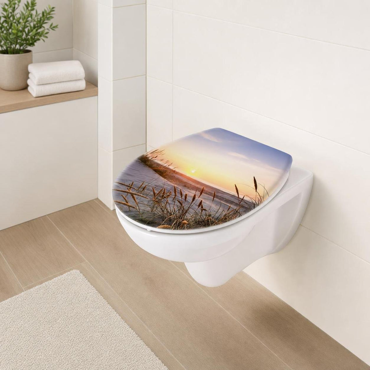 Der WC-Sitz zeigt ein Strandmotiv bei Sonnenuntergang im hellen Bad.