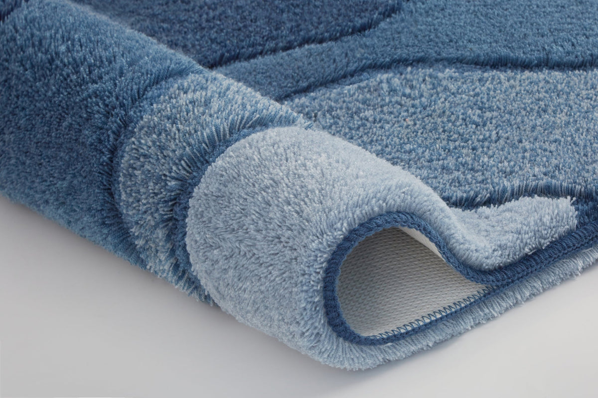 Nahaufnahme einer gerollten, zweifarbigen blauen Badematte aus Flor