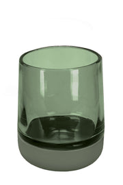Grüner, transparenter Zahnputzbecher aus Glas vor weißem Hintergrund