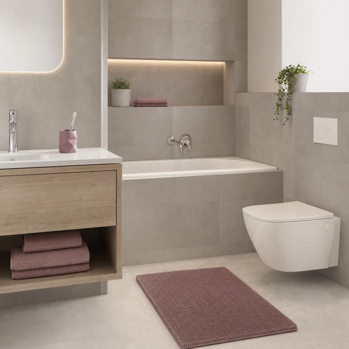 Rosa Badteppich liegt vor Badewanne und WC in modernem Badezimmer.